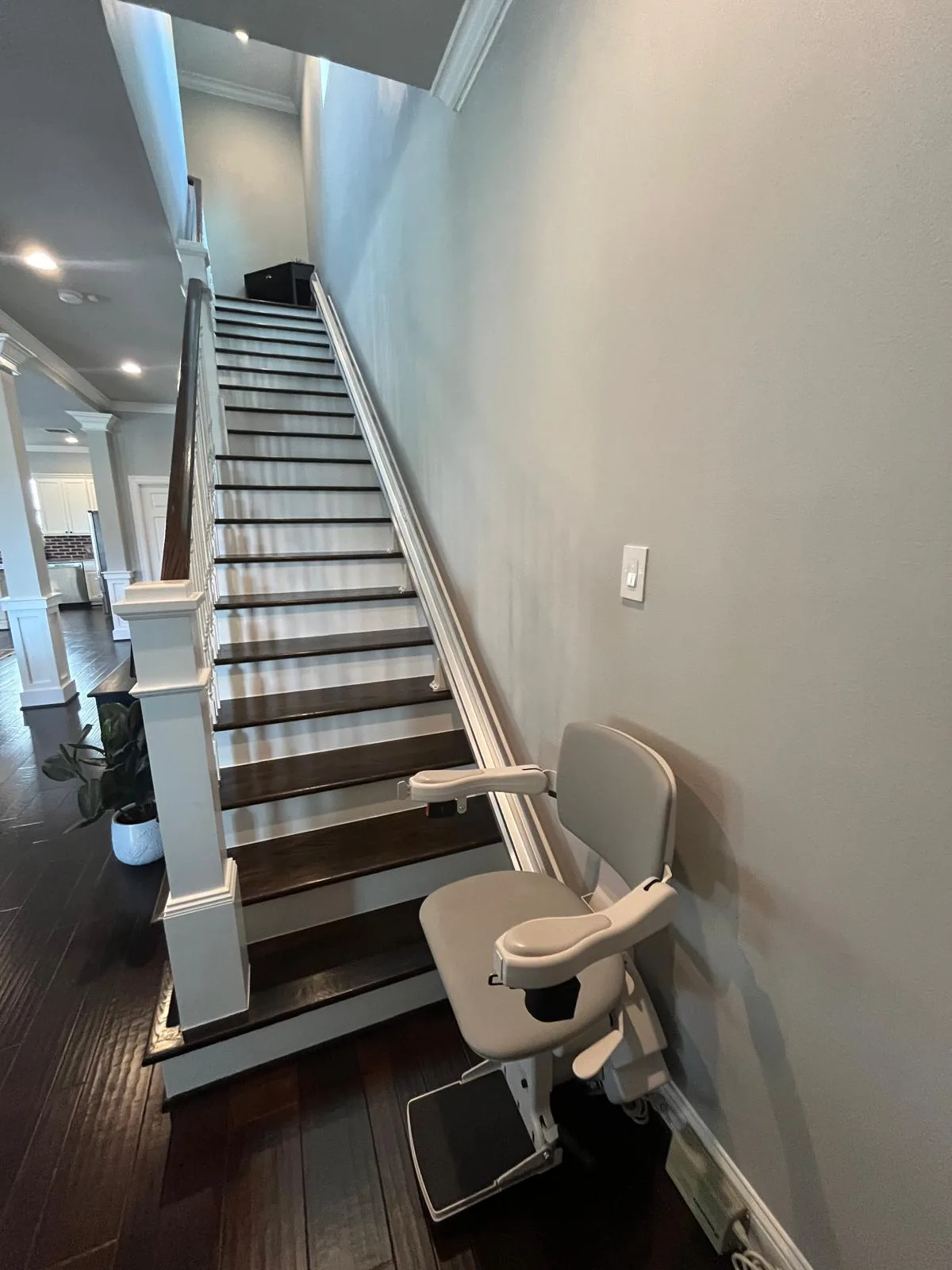A chairlift at the foot of the staircase, on a rail running up the wall to the bedrooms